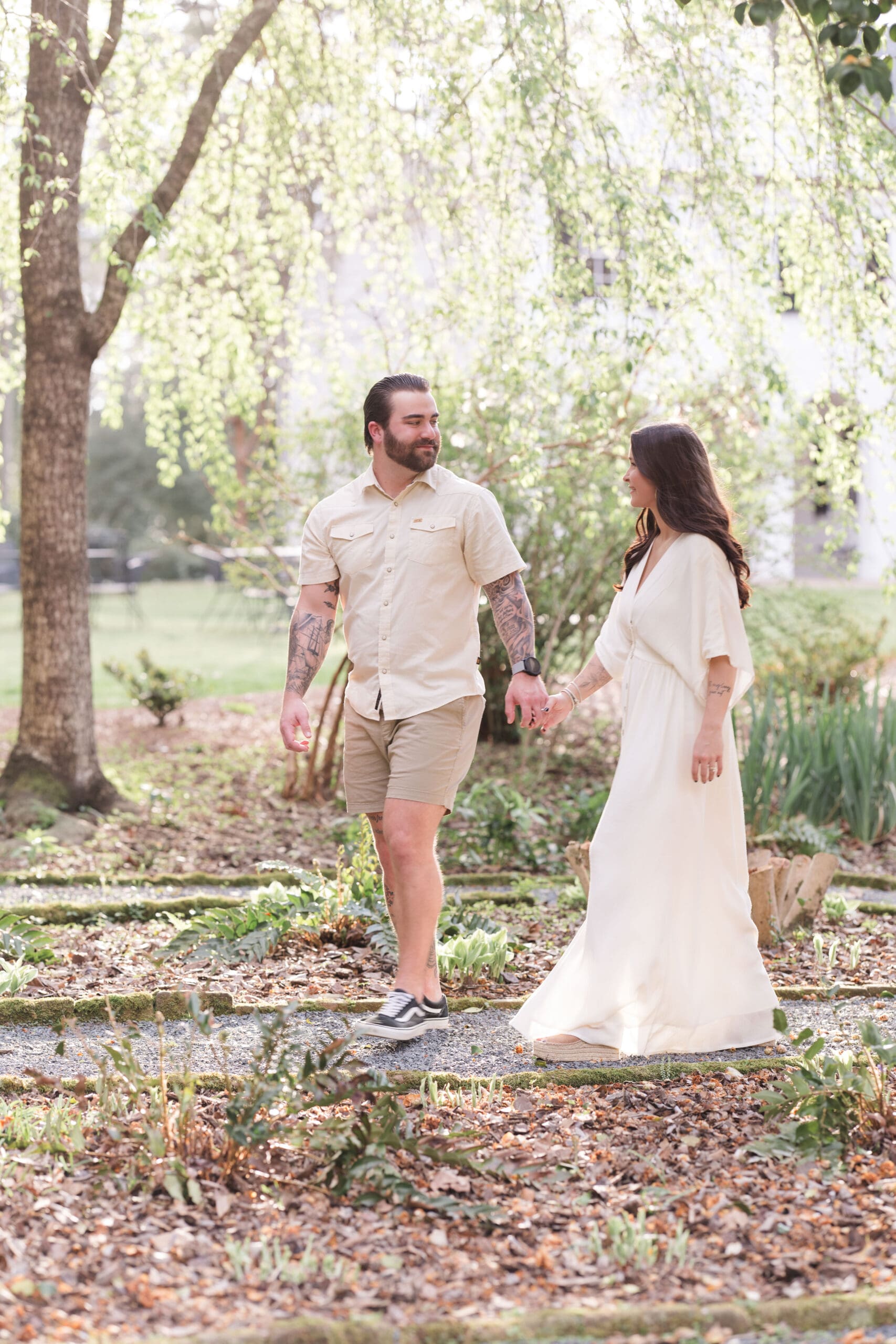 A couple walking through a sunlit spring garden.
