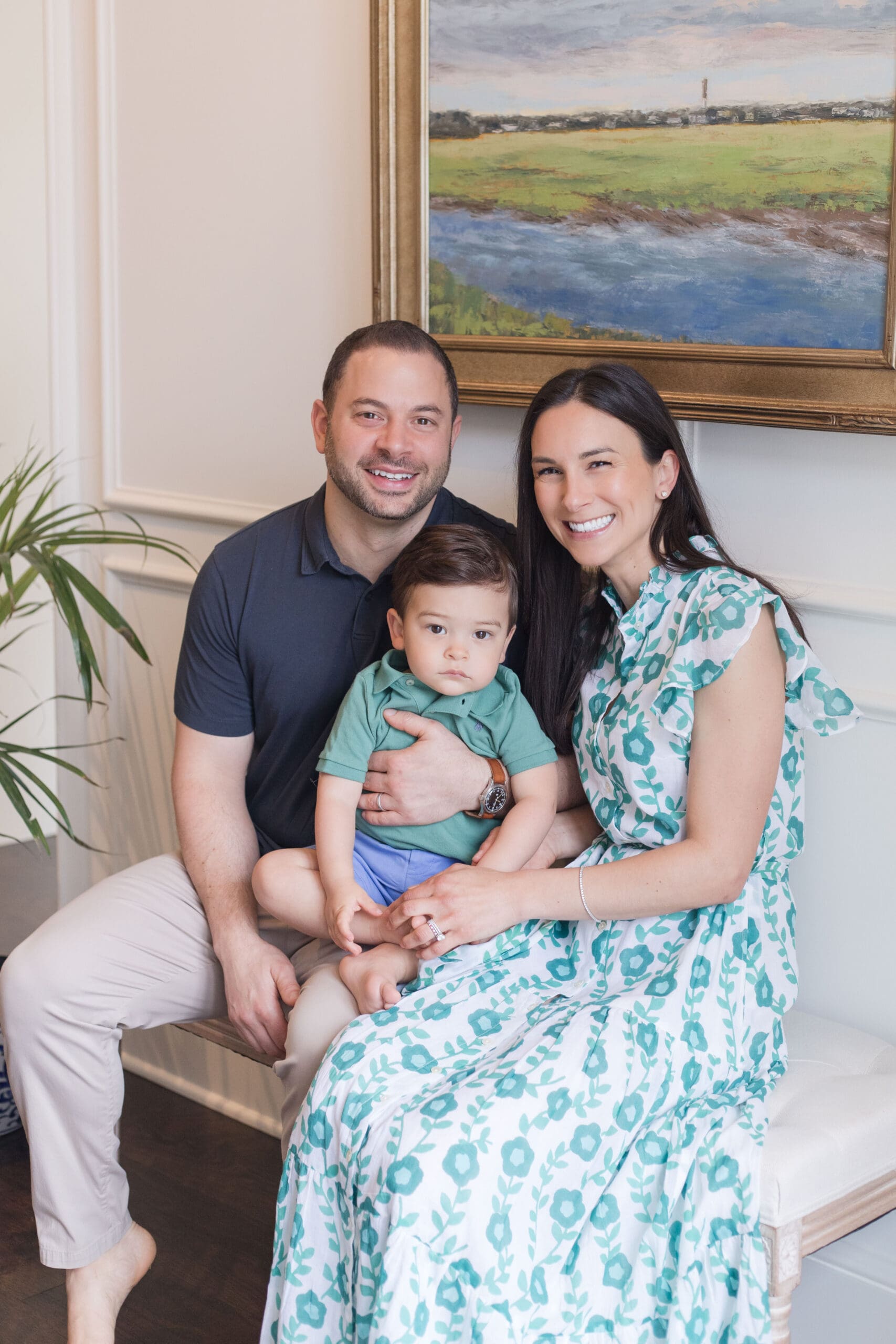 Family of three posing in a bright living room during an in-home family session in Charlotte, NC
